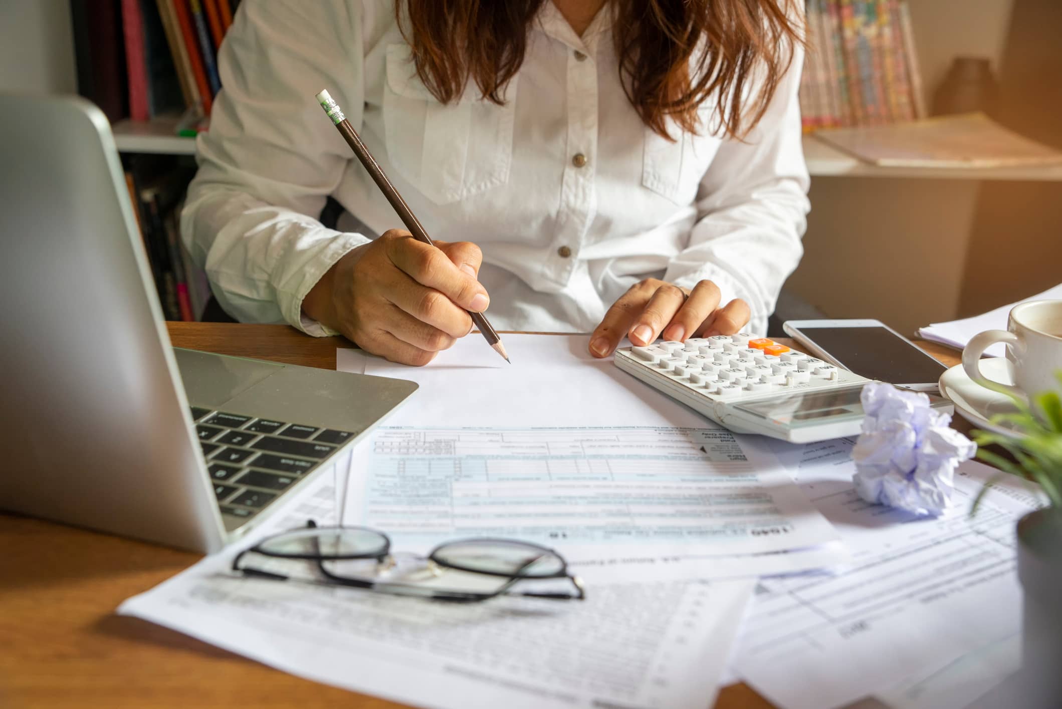 woman surrounded by papers and a calculator