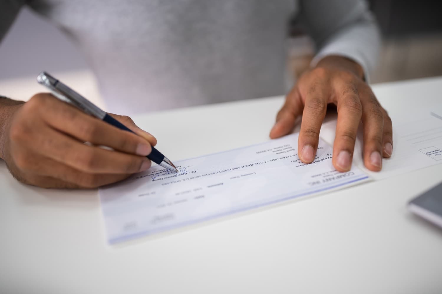Businessperson signing a paycheck