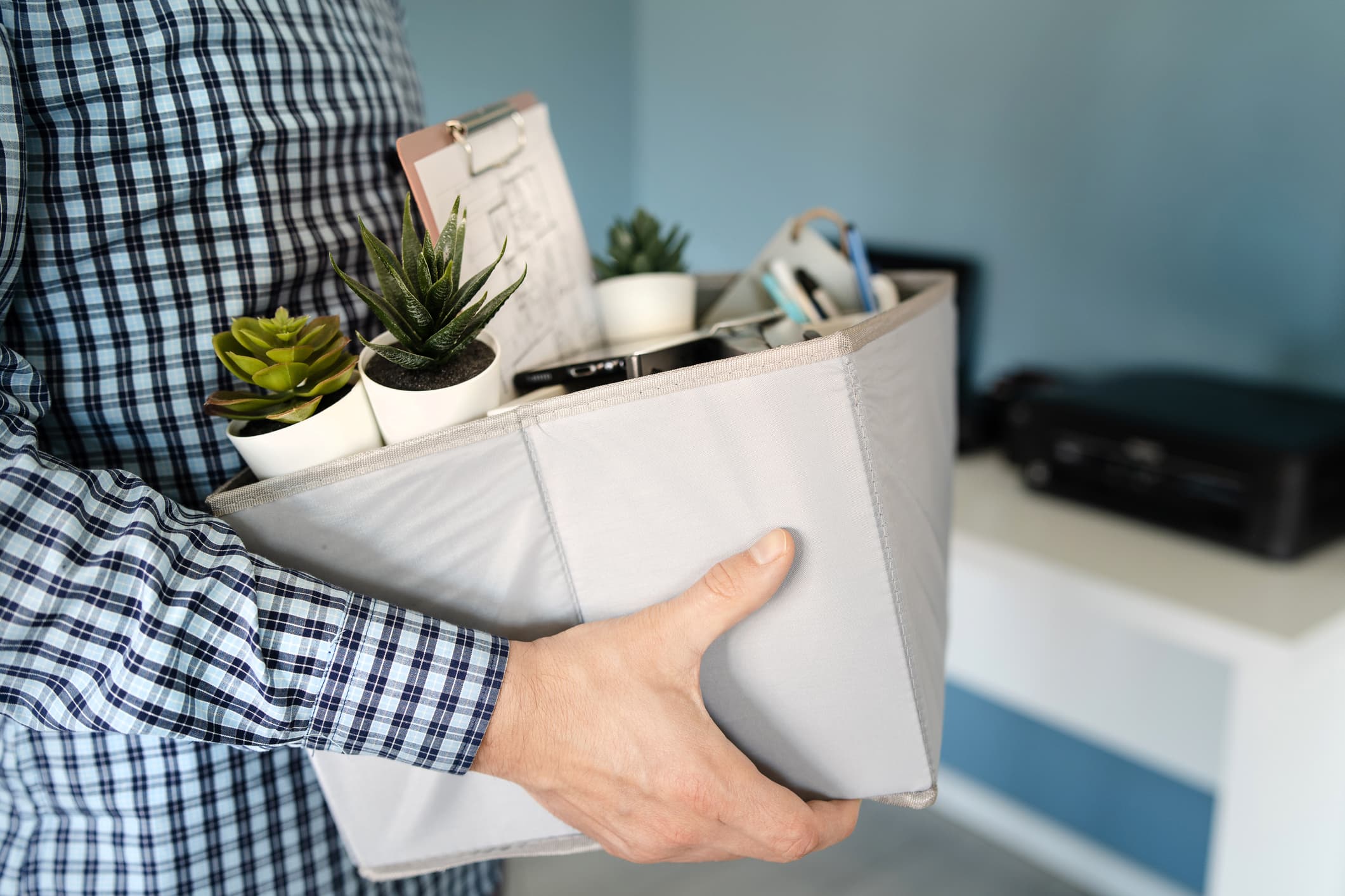 Midsection close up of unknown caucasian man holding a box with personal items stuff leaving the office after being fired from work due recession economic crisis downturn losing job company shutdown