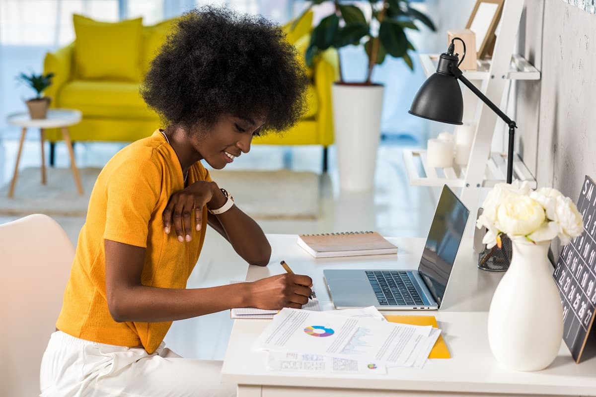 smiling woman at a desk with a laptop